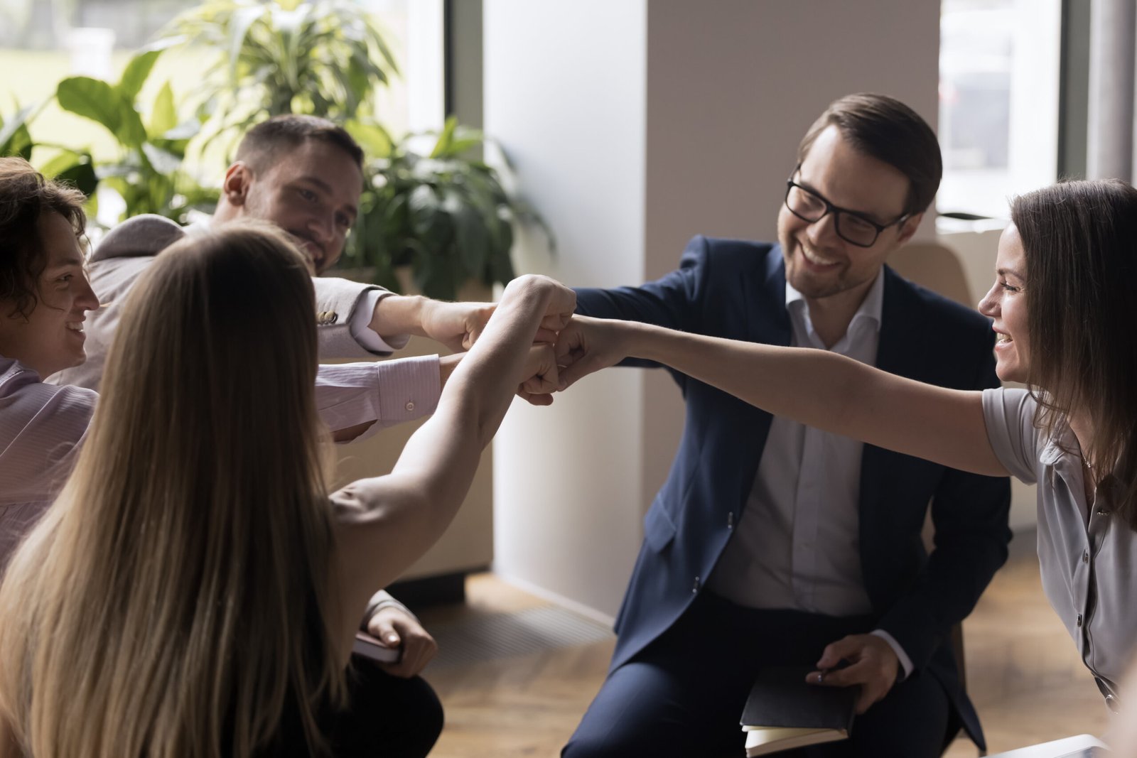 group of enthusiastic businesspeople fist bumping showing solidarity and support