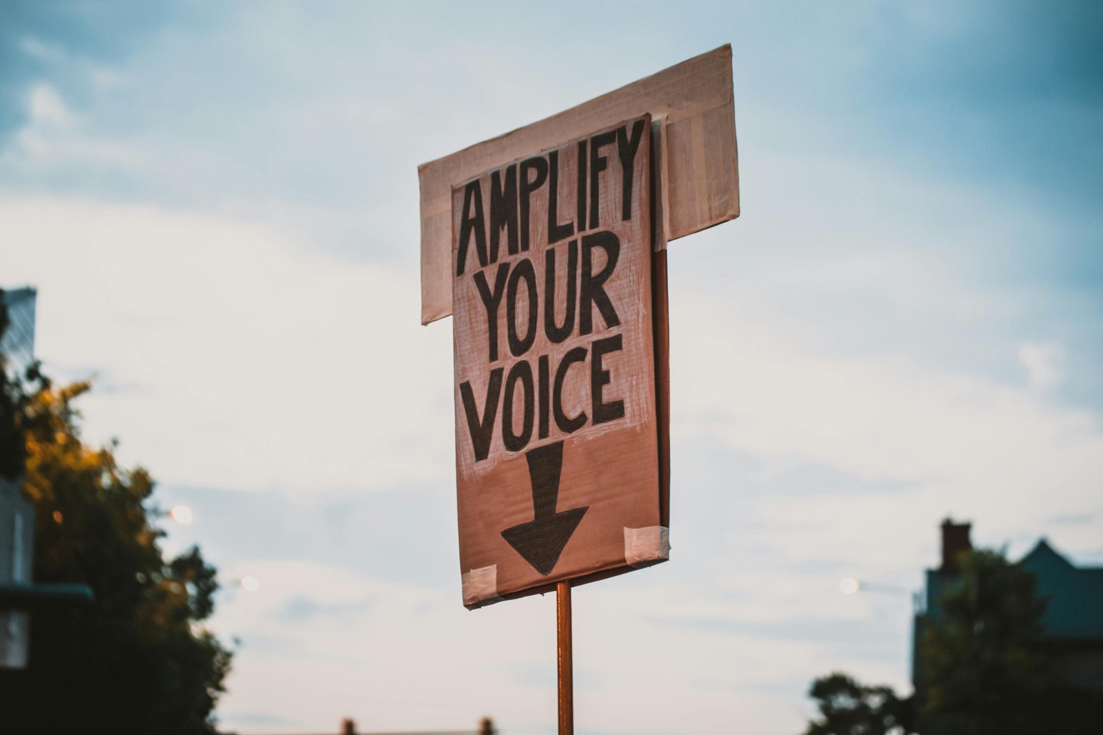 Close-up of a protest sign in an outdoor setting with a motivational message.